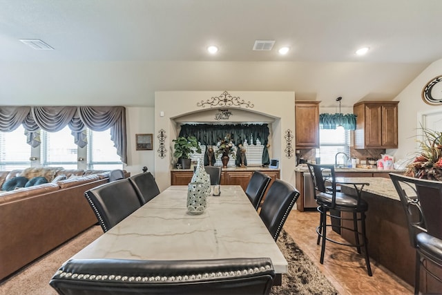 dining space with plenty of natural light, sink, and lofted ceiling