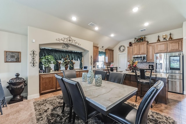 tiled dining room featuring lofted ceiling