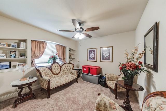 living area featuring ceiling fan and carpet