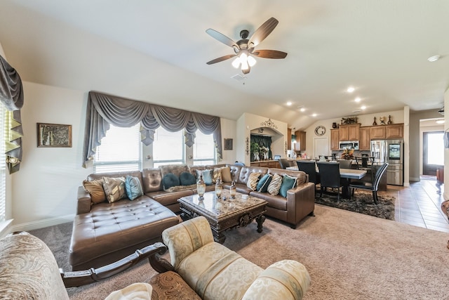 living room with ceiling fan, light colored carpet, and vaulted ceiling