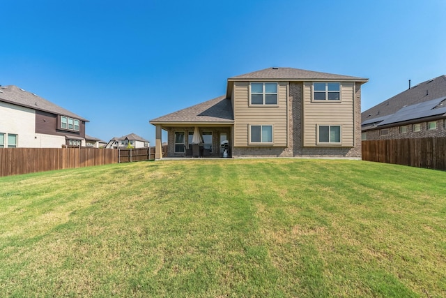 rear view of property featuring a lawn