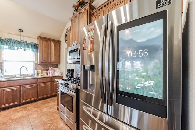 kitchen with sink, vaulted ceiling, light tile patterned floors, stainless steel appliances, and decorative backsplash