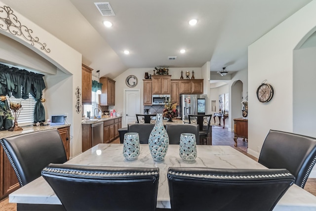 dining room featuring vaulted ceiling and sink