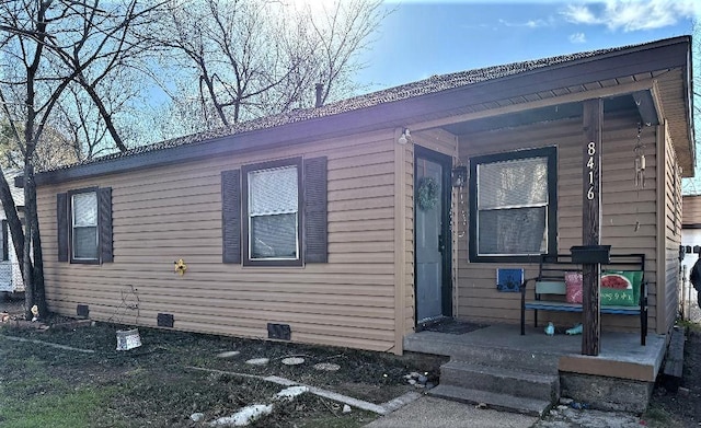 view of side of property featuring covered porch