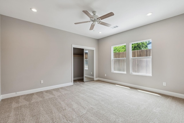 unfurnished bedroom featuring light carpet, a closet, and ceiling fan