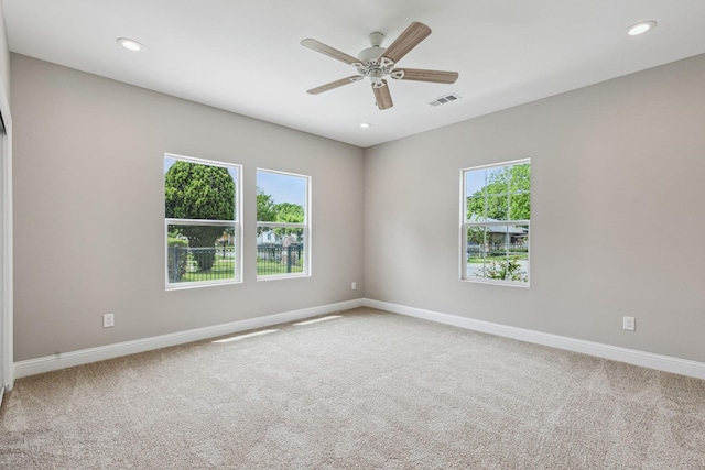 carpeted spare room with ceiling fan