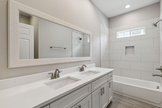 bathroom featuring tiled shower / bath combo and vanity