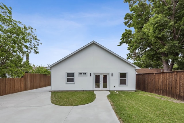 back of property with a patio, a lawn, and french doors