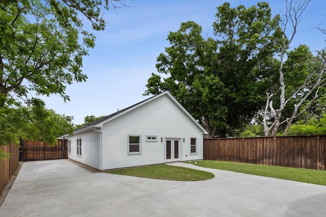 rear view of property featuring a patio area, french doors, and a lawn