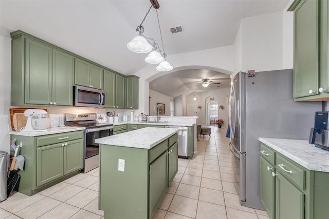 kitchen featuring stainless steel appliances, a center island, pendant lighting, and green cabinetry