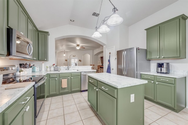 kitchen featuring ceiling fan, appliances with stainless steel finishes, hanging light fixtures, green cabinetry, and a kitchen island