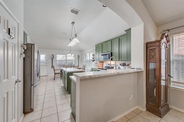 kitchen featuring light tile patterned floors, appliances with stainless steel finishes, green cabinets, decorative light fixtures, and kitchen peninsula