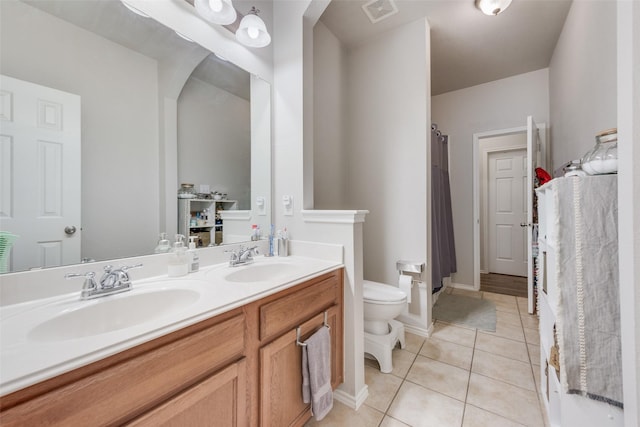 bathroom featuring tile patterned flooring, vanity, and toilet