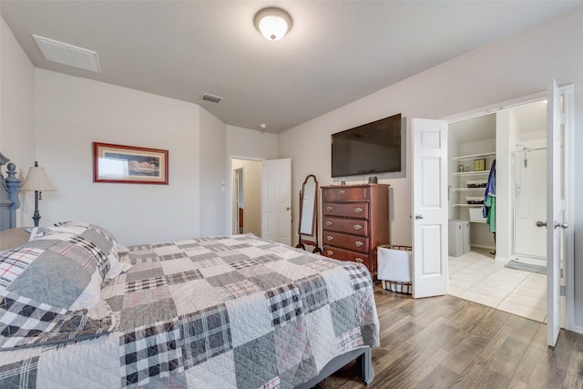 bedroom featuring wood-type flooring, a spacious closet, and a closet