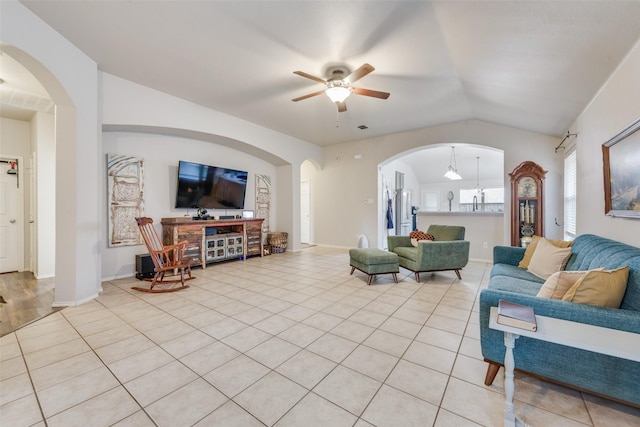 tiled living room with ceiling fan and vaulted ceiling