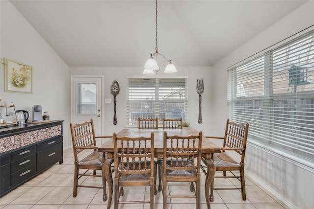 dining space featuring light tile patterned floors, vaulted ceiling, and a chandelier