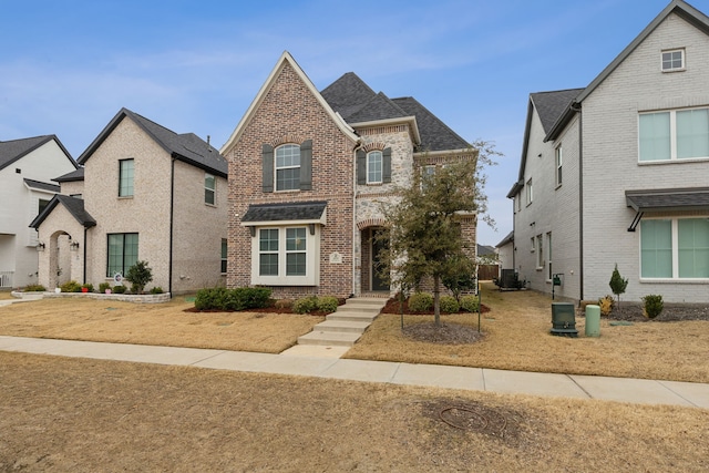 view of front of property featuring central air condition unit and brick siding