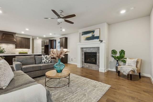 living area featuring wood finished floors, a ceiling fan, baseboards, recessed lighting, and a tile fireplace