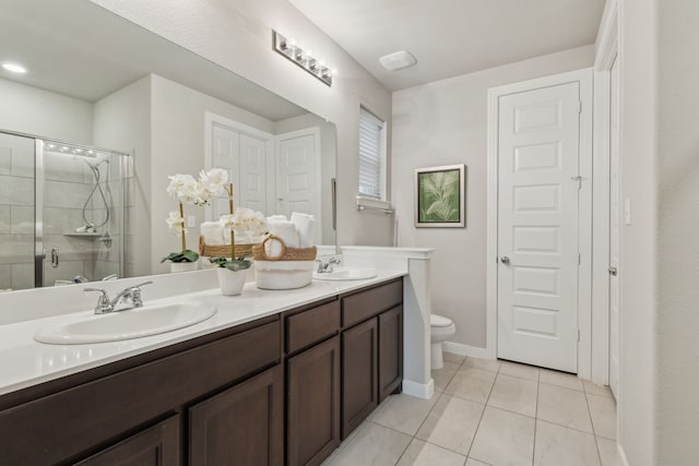 bathroom with vanity, tile patterned flooring, a shower with door, and toilet