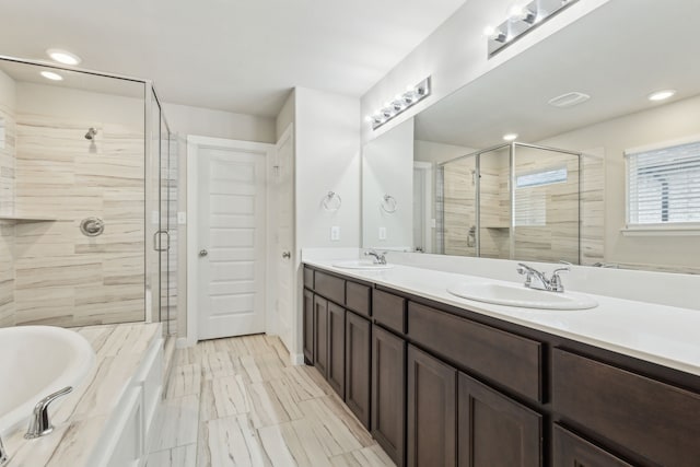 bathroom featuring vanity and independent shower and bath