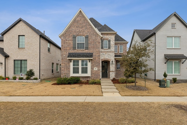 view of front of home featuring brick siding and a shingled roof