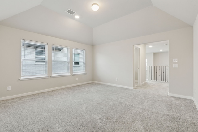 spare room with visible vents, light carpet, recessed lighting, baseboards, and vaulted ceiling