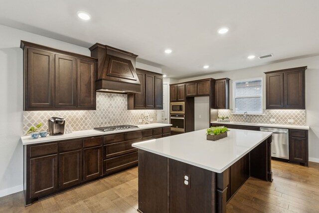 unfurnished living room with a tile fireplace, sink, hardwood / wood-style floors, and ceiling fan