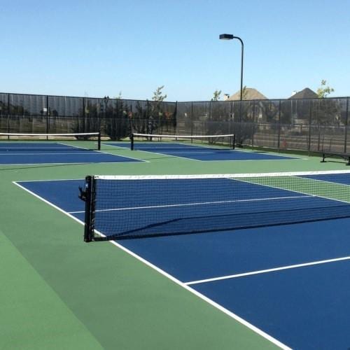 view of tennis court featuring community basketball court and fence