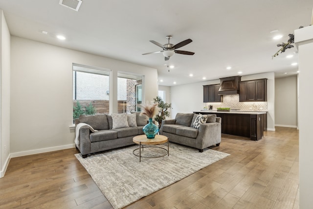 living area with recessed lighting, visible vents, light wood-style flooring, and ceiling fan