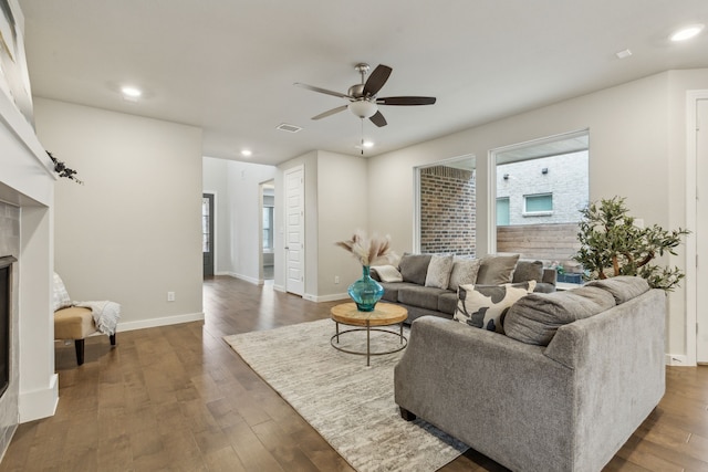 living room featuring visible vents, plenty of natural light, wood finished floors, and a ceiling fan