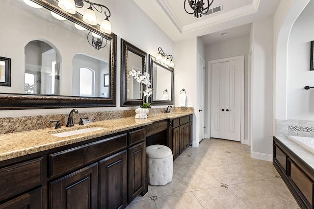 full bath with a tray ceiling, double vanity, visible vents, a sink, and baseboards