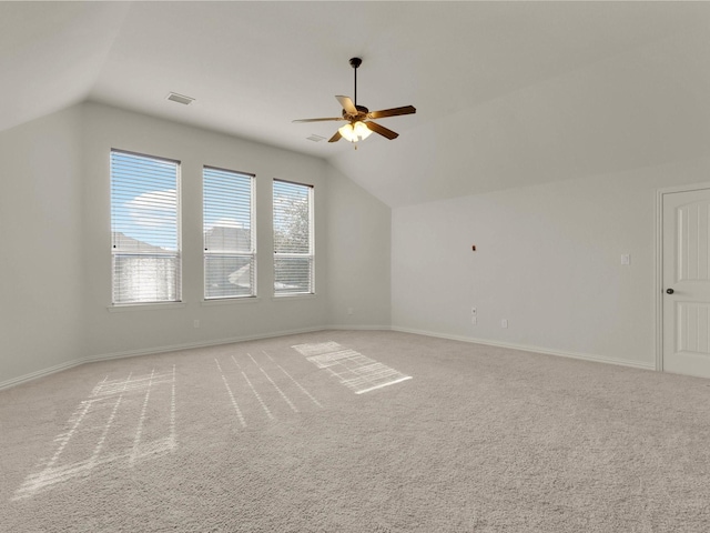 bonus room featuring lofted ceiling, visible vents, a ceiling fan, light carpet, and baseboards