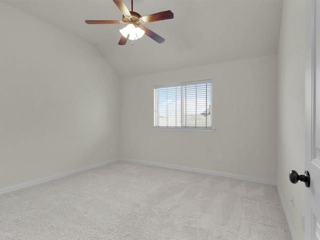carpeted spare room featuring vaulted ceiling, baseboards, and ceiling fan