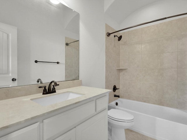 full bathroom with tile patterned flooring, tiled shower / bath, vanity, and toilet