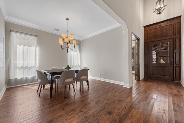 dining space featuring arched walkways, baseboards, a notable chandelier, dark wood-type flooring, and ornamental molding