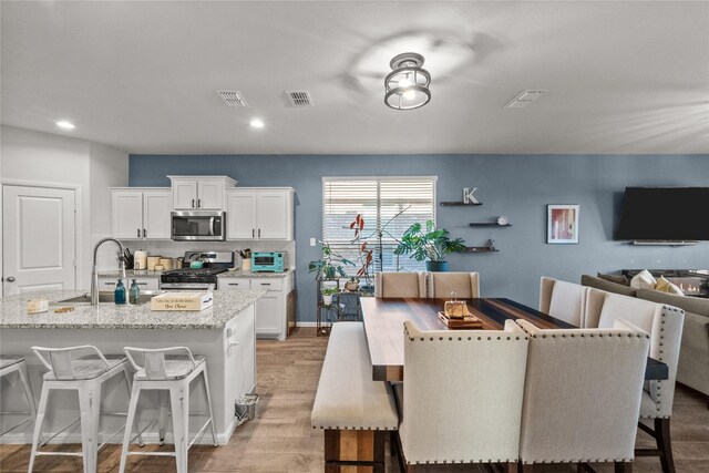 dining space featuring sink and light hardwood / wood-style flooring