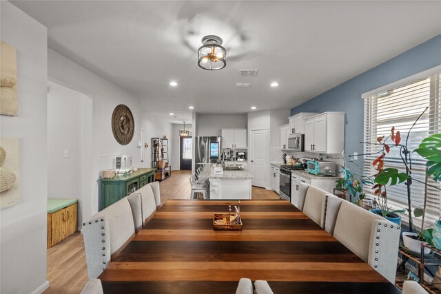 dining room featuring sink and light hardwood / wood-style flooring