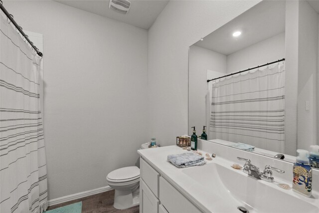 bathroom featuring vanity, hardwood / wood-style flooring, and toilet