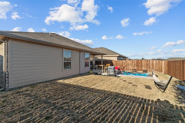 rear view of property featuring a pool and a patio