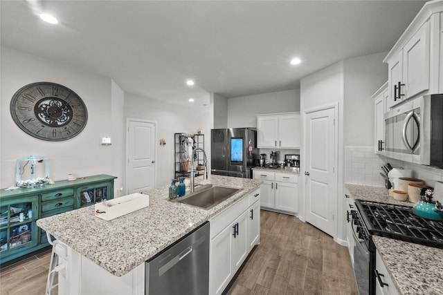 kitchen featuring white cabinetry, an island with sink, appliances with stainless steel finishes, and sink