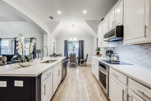 kitchen with sink, white cabinetry, appliances with stainless steel finishes, an island with sink, and pendant lighting