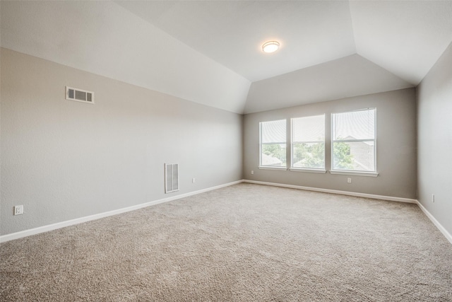 empty room featuring lofted ceiling and carpet