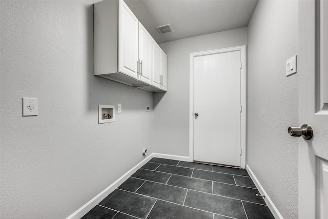 laundry room with cabinets, washer hookup, hookup for an electric dryer, and dark tile patterned floors