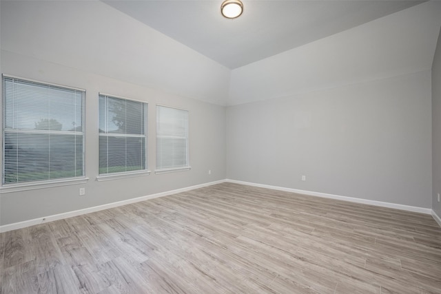 empty room featuring lofted ceiling and light hardwood / wood-style floors