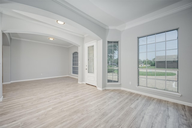 spare room with crown molding and light wood-type flooring