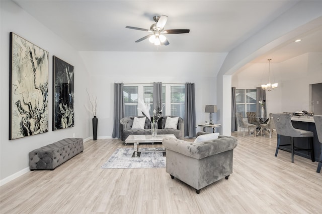 living room featuring ceiling fan with notable chandelier, lofted ceiling, and light hardwood / wood-style floors