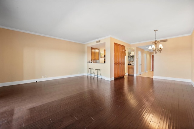 unfurnished living room with an inviting chandelier, dark hardwood / wood-style floors, and crown molding