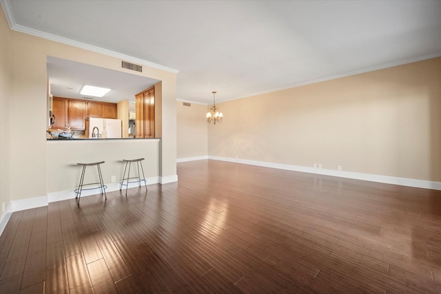 unfurnished living room featuring ornamental molding, a chandelier, and dark hardwood / wood-style flooring