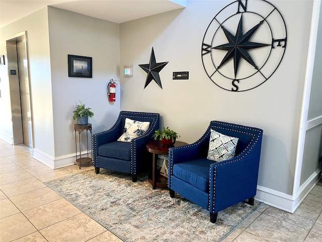 living area featuring elevator and tile patterned flooring