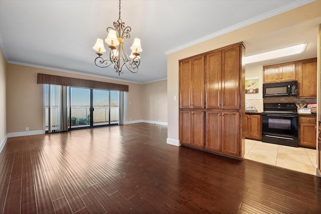 kitchen featuring decorative light fixtures, wood-type flooring, decorative backsplash, black appliances, and crown molding